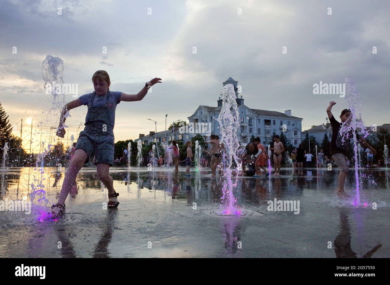 Kramatorsk, Ucraina. 25 Giugno 2021. I bambini si divertono alla fontana centrale dopo una giornata calda, quando la temperatura scende a 28 gradi Celsius (82, 4 gradi Fahrenheit) a Kramatorsk. I residenti dell'Ucraina orientale sono avvilenti sotto le temperature calde e l'umidità che hanno colpito in giugno. La temperatura di metà pomeriggio di 34 Celsius (93, 2 Fahrenheit) credito: SOPA Images Limited/Alamy Live News Foto Stock