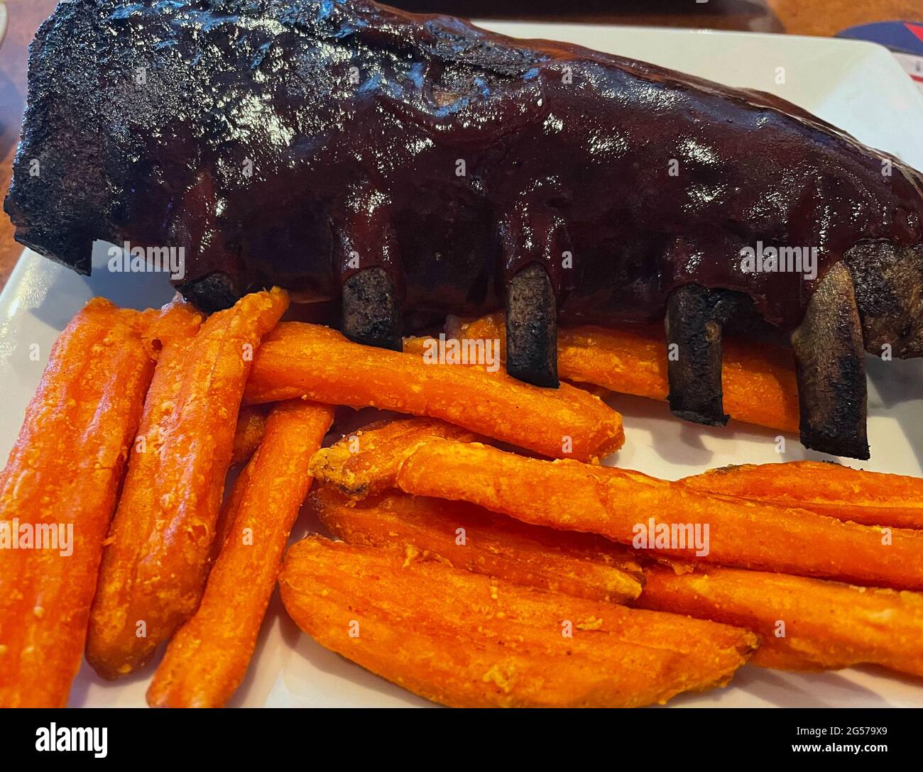 BBQ 1/2 costolette per bambini con patate dolci fritte Foto Stock