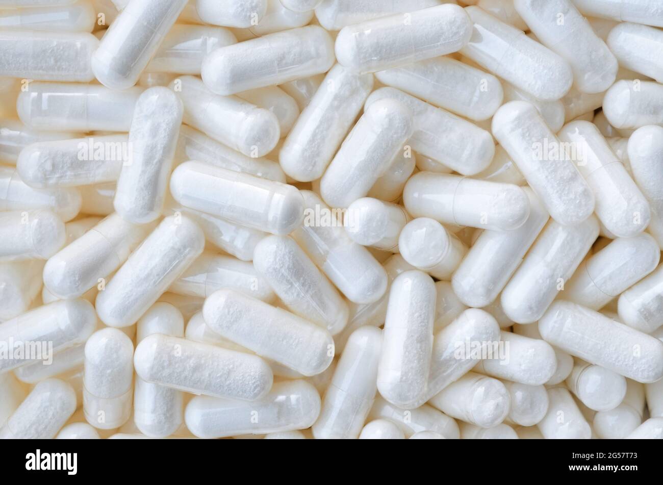 Un sacco di pillole bianche-capsule come sfondo, vista dall'alto. Concetto di assistenza sanitaria. Foto Stock