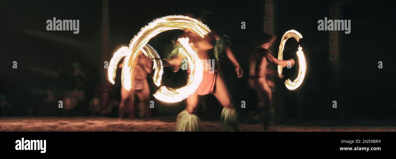 Luau party polinesiana danzatori fuoco gettando torce di notte sulla spiaggia resort. Attività culturale hawaiana, bandiera della cultura polinesia Foto Stock