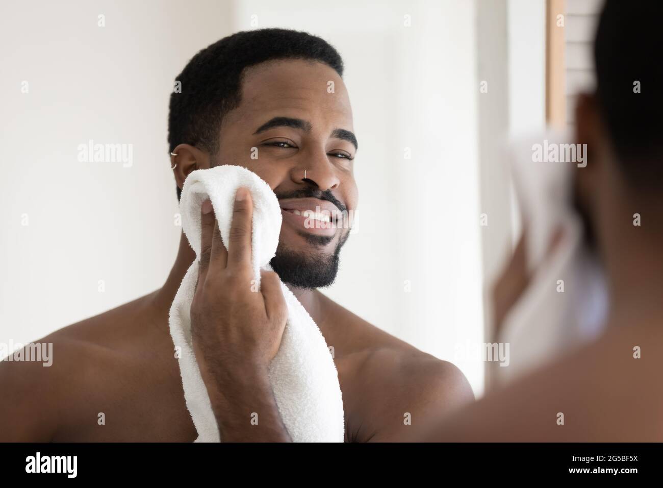 Felice bel viso afro-americano che asciuga con asciugamano bianco Foto Stock