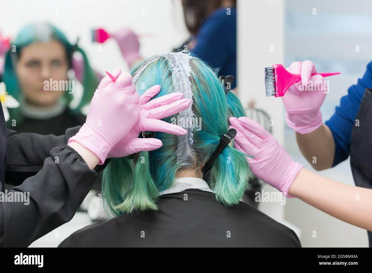 Due professionisti master parrucchieri applicare la vernice ai capelli  della donna durante la decolorazione delle radici dei capelli. Processo di  tintura per capelli in salone di bellezza professionale Foto stock - Alamy