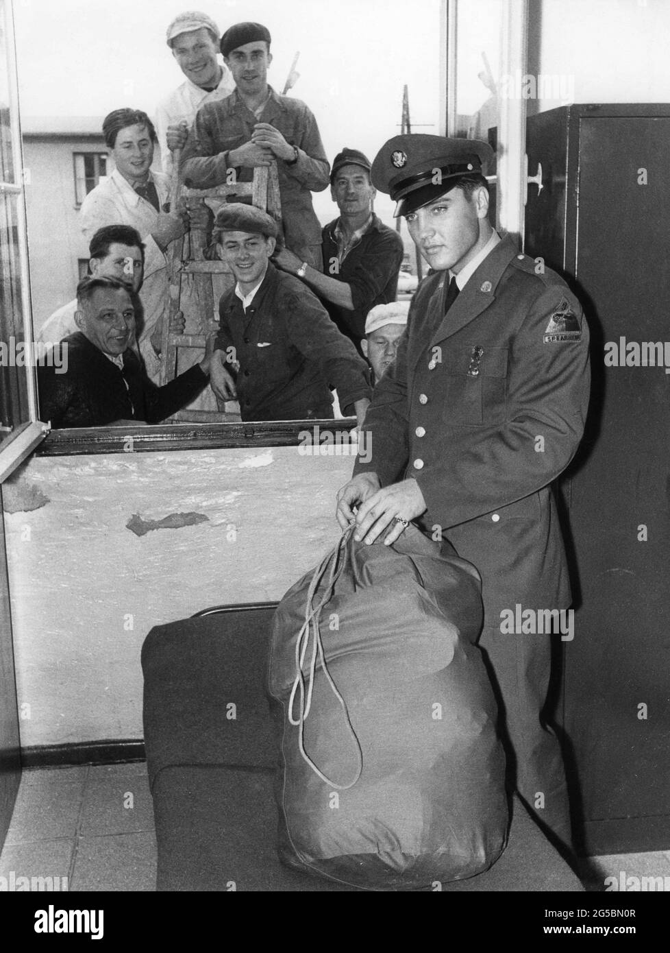 ELVIS PRESLEY nella sua Camera di Barrack Alloggio con operai alla finestra di Friedberg all'arrivo in Germania per Servizio militare con la terza Divisione americana del carro armato il 2 ottobre 1958 Foto Stock