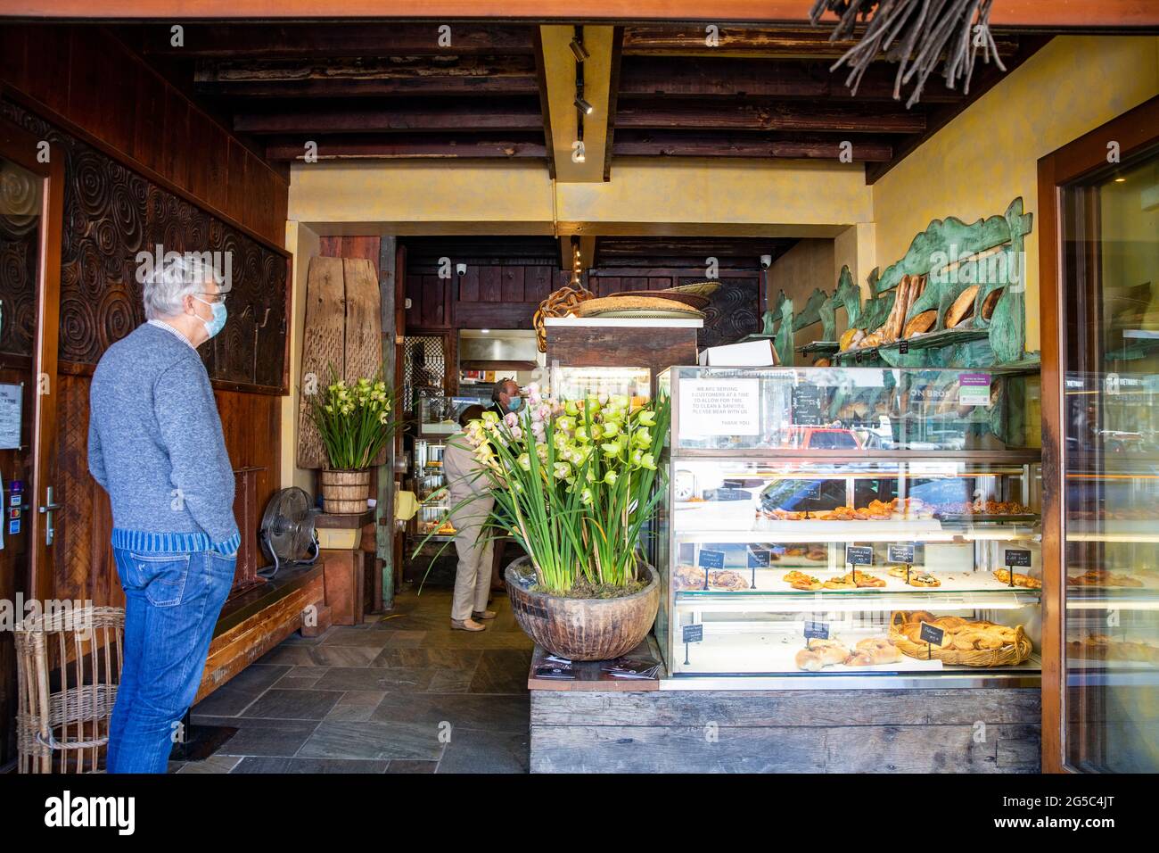Uomo anziano che indossa facemask durante il covid 19 sydney lockdown attende ad una panetteria per acquistare pane, Sydney, Australia Foto Stock