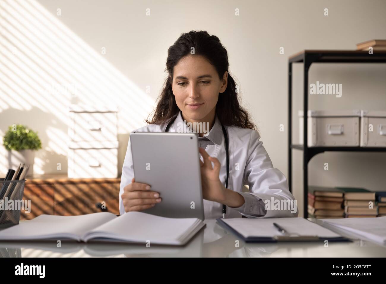 Una donna caucasica parla di videochiamata su tablet Foto Stock
