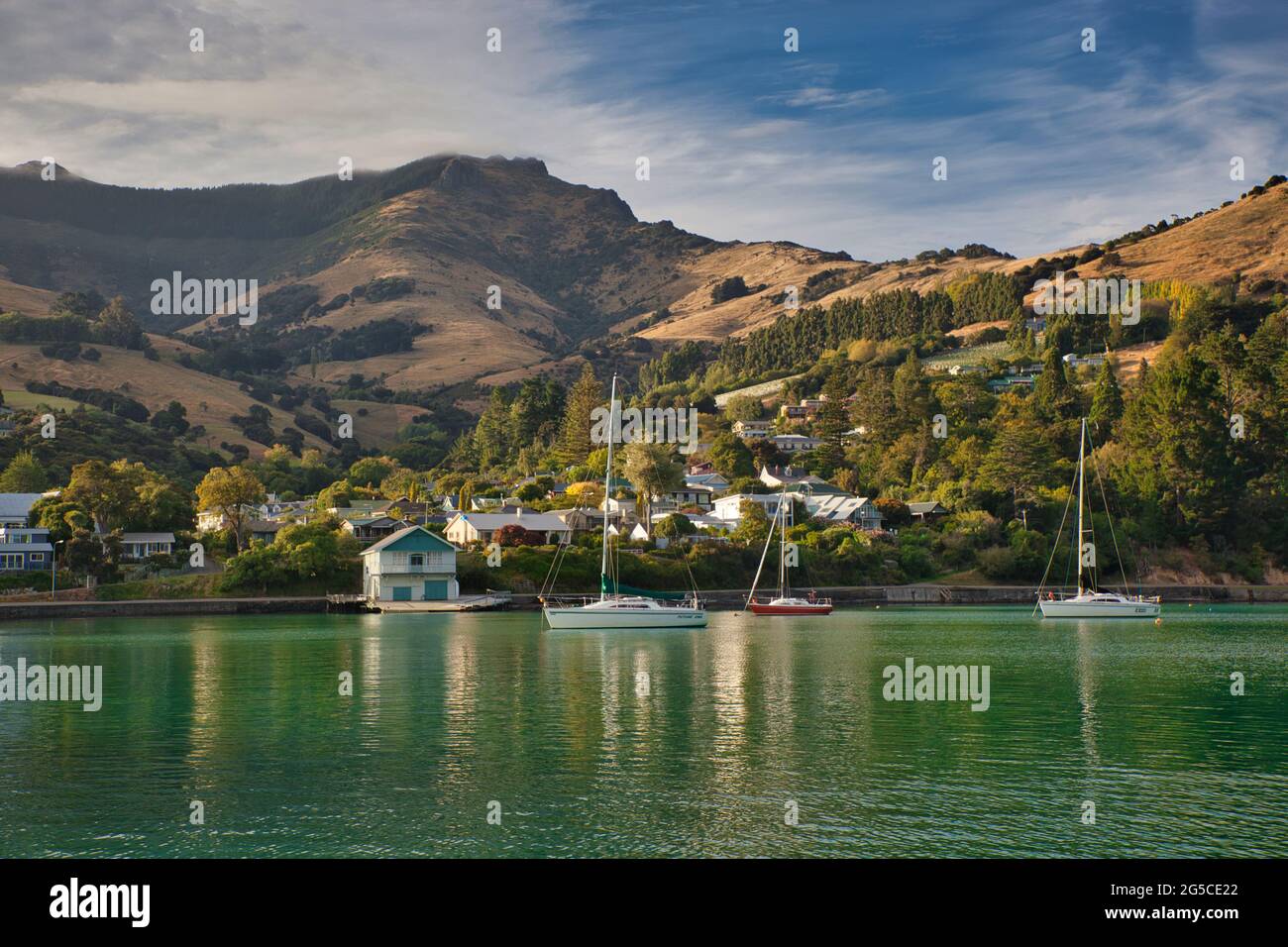 Bella cornice di colline, case, piccole barche e yacht in ormeggi, sulla costa orientale di South Island, Nuova Zelanda Foto Stock
