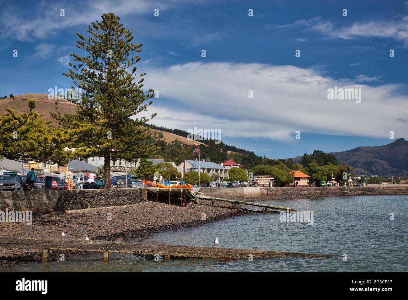Bella scena di un lungomare con negozi e case sopra una spiaggia, sulla costa orientale di South Island, Nuova Zelanda Foto Stock