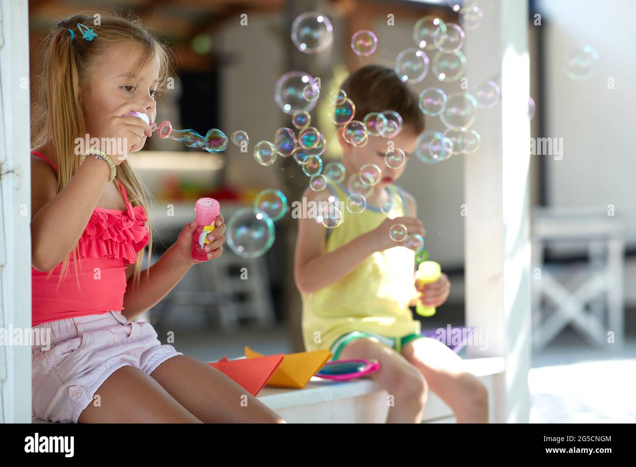 carina bambina insegnando al fratello come fare sapone bolle Foto Stock