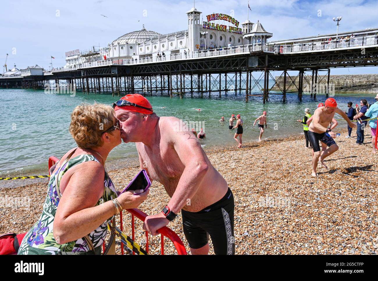 Brighton, Regno Unito. 26 giugno 2021. Questo concorrente ottiene un bacio ben fatto dopo aver completato la Brighton Pier to Pier Swim Race, che è uno dei più storici eventi di nuoto in mare aperto in Gran Bretagna: Credit Simon Dack / Alamy Live News Foto Stock