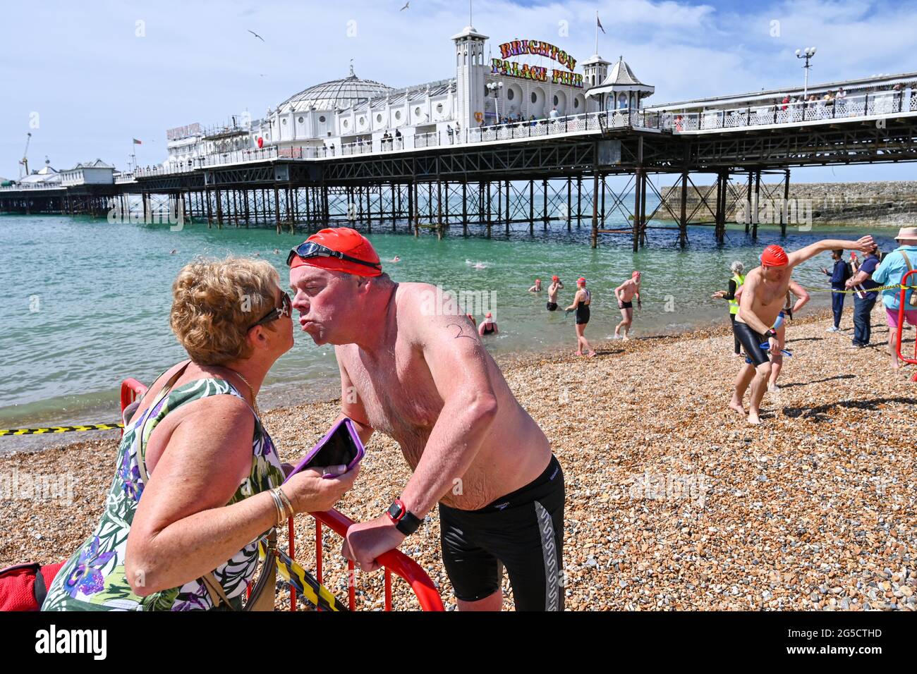 Brighton, Regno Unito. 26 giugno 2021. Questo concorrente ottiene un bacio ben fatto dopo aver completato la Brighton Pier to Pier Swim Race, che è uno dei più storici eventi di nuoto in mare aperto in Gran Bretagna: Credit Simon Dack / Alamy Live News Foto Stock