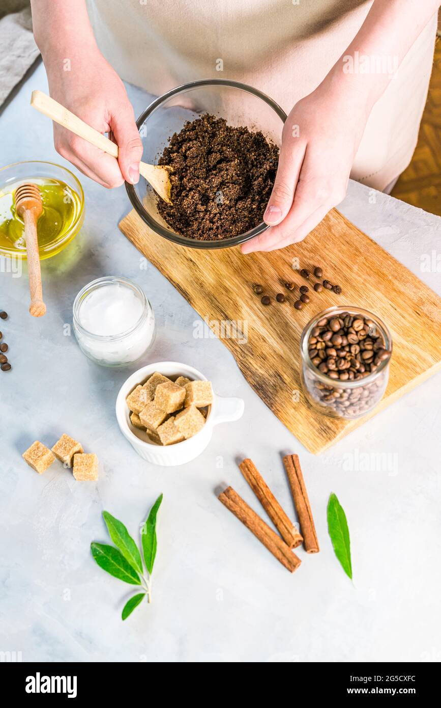 Donna miscelazione ingredienti preparazione scrub caffè o maschera per il trattamento della pelle Foto Stock