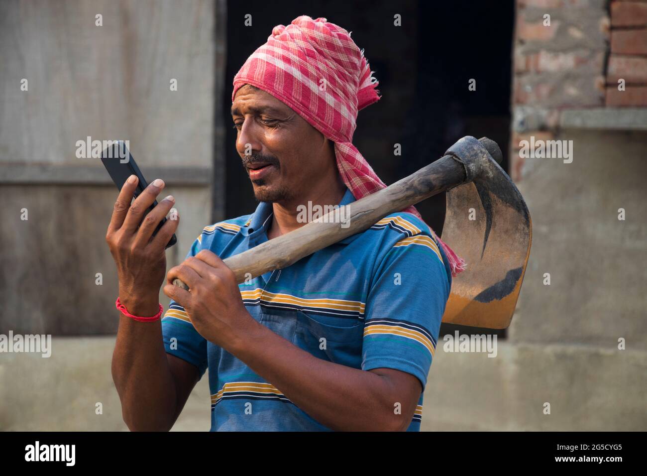 Rural Indian Man Holding telefono cellulare Foto Stock