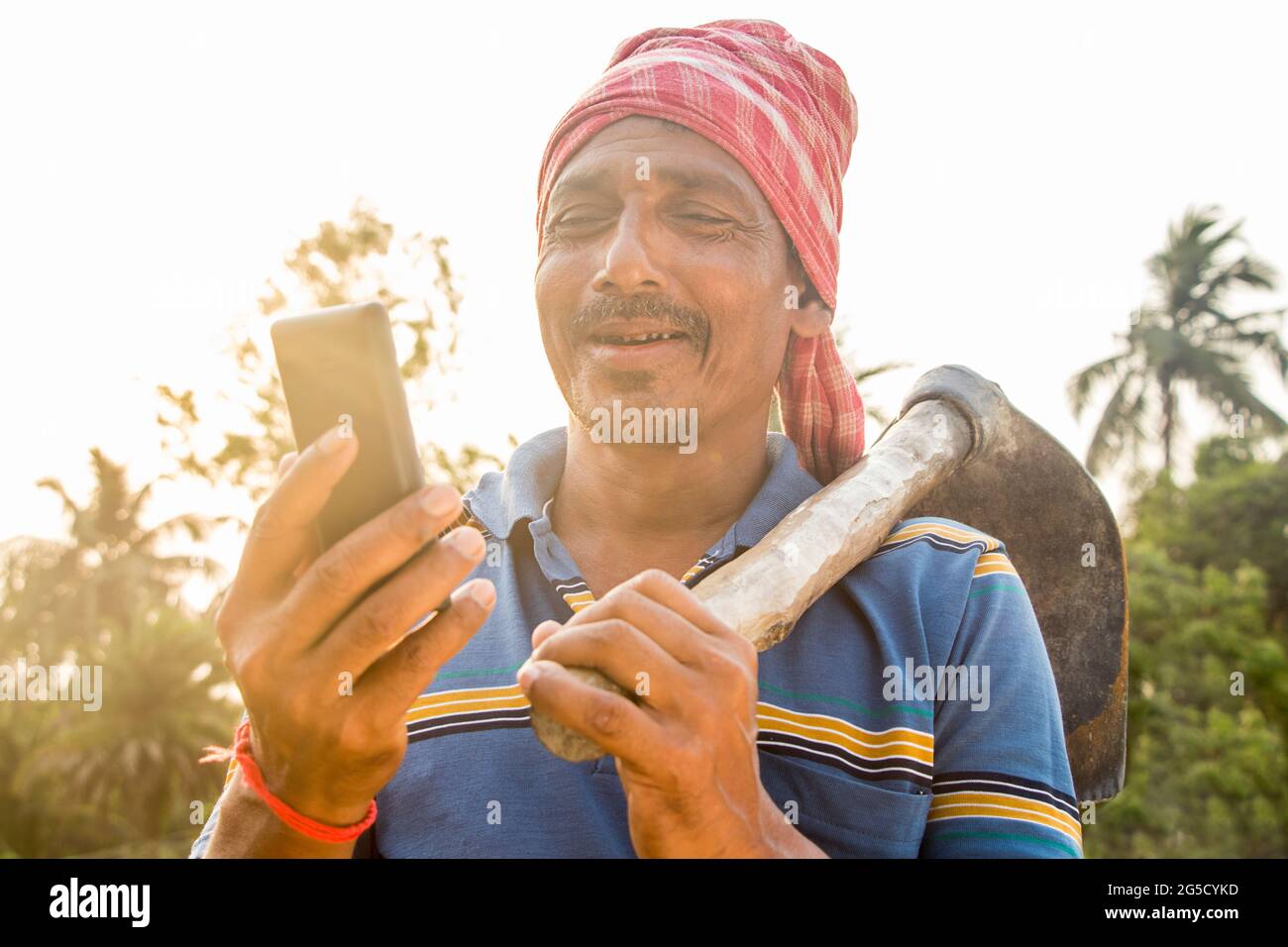 Rural Indian Man Holding telefono cellulare Foto Stock
