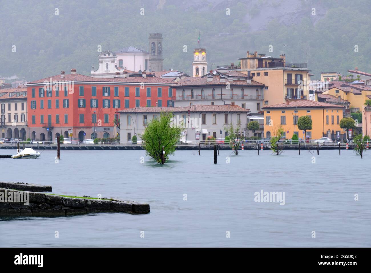 Vista sul lungomare di un piccolo paese sul Lago d'Iseo in una giornata piovosa, Brescia, Lombardia, Italia Foto Stock