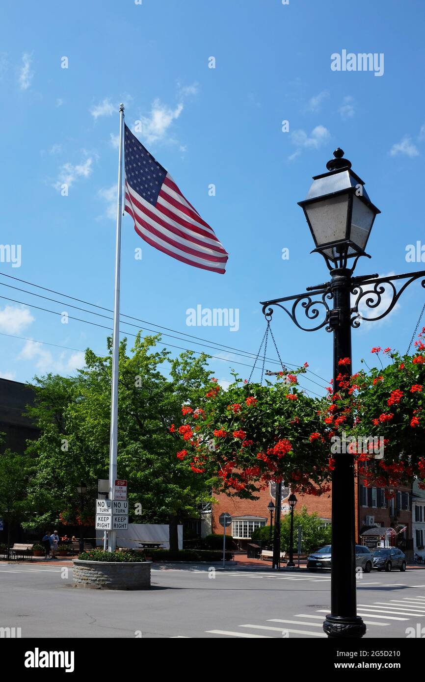 COOPERSTOWN, NEW YORK - 21 GIUGNO 2021: Bandiera e lampione all'incrocio tra Main Street e Pioneer Street nella città di Upstate e casa dei Nati Foto Stock