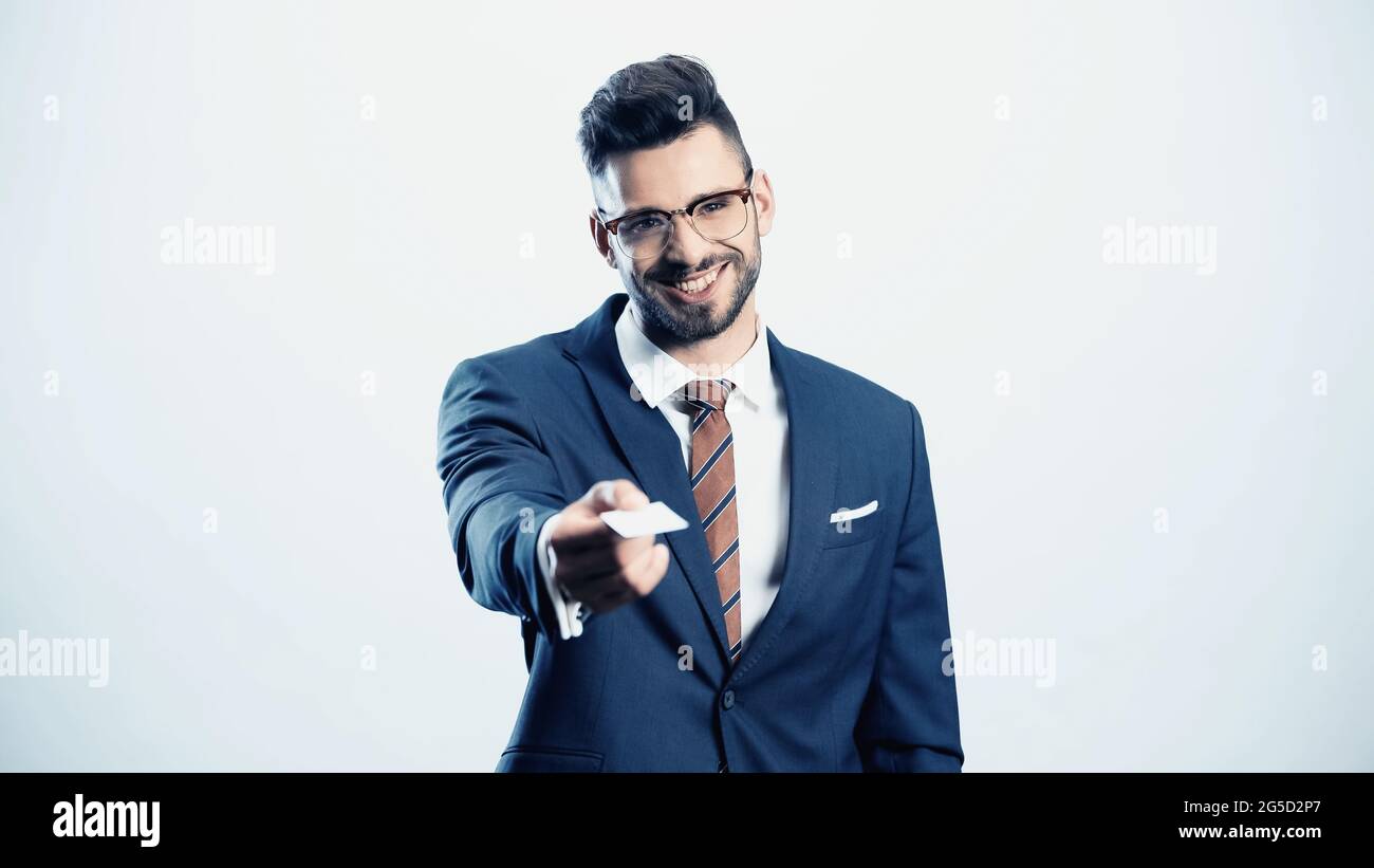 uomo d'affari riuscito che tiene il biglietto da visita in mano estensibile isolato su bianco Foto Stock