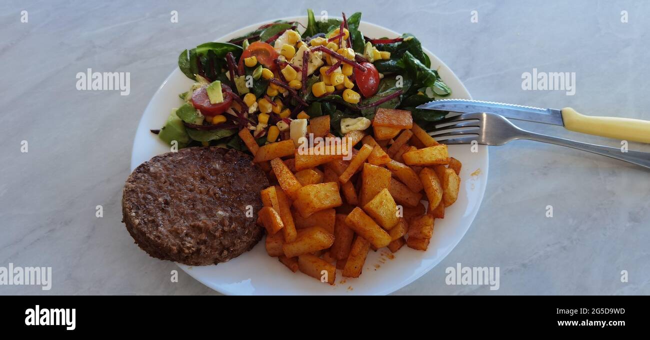 Insalata, patatine fritte affumicate e hamburger di Quorn Foto Stock