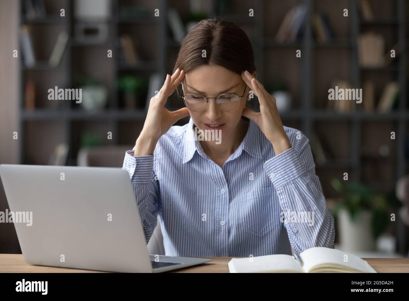 Stressato infelice giovane donna che soffre di mal di testa. Foto Stock