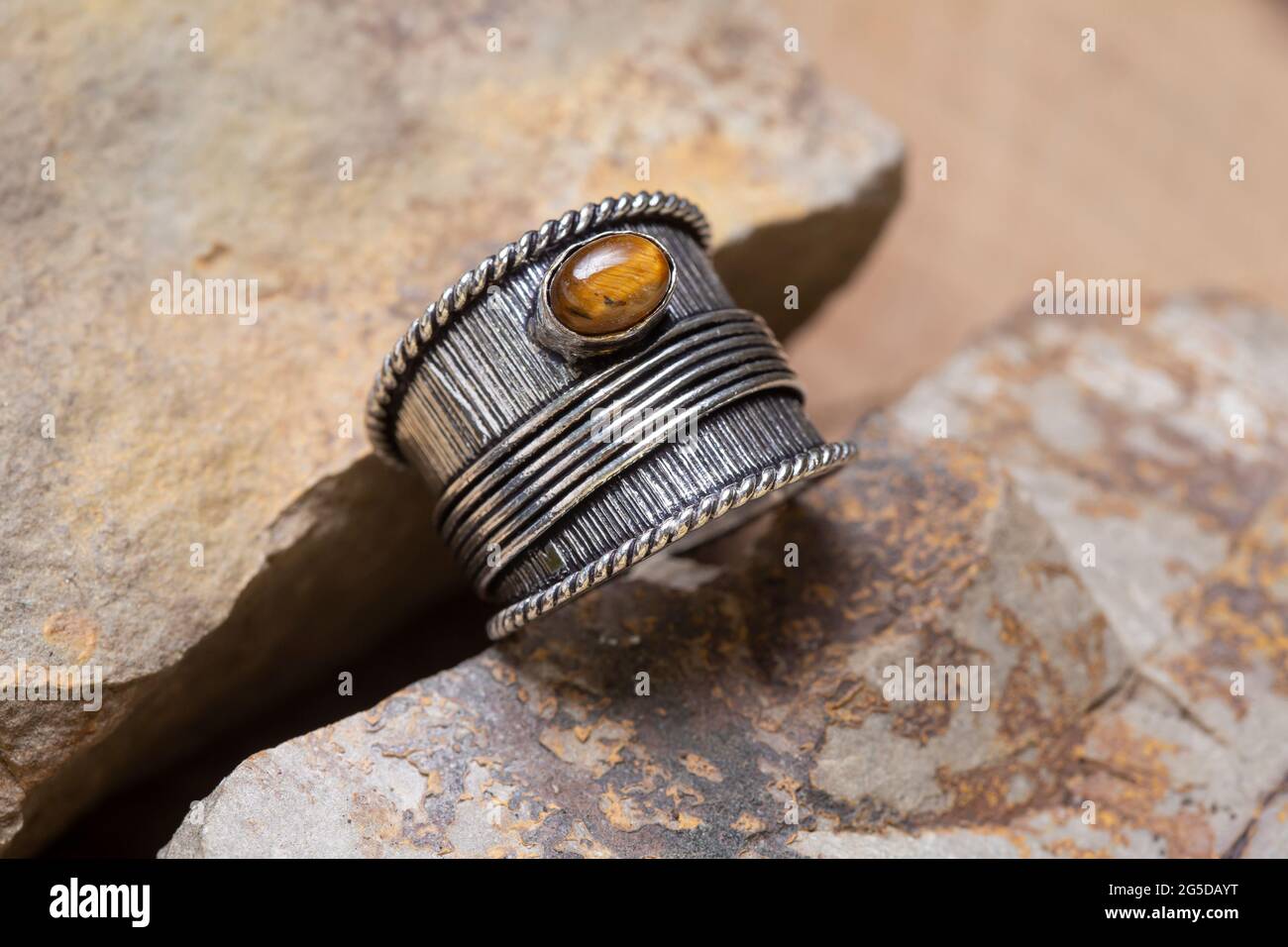 Ottone metallo tigre occhio minerale pietra anello su sfondo naturale Foto Stock