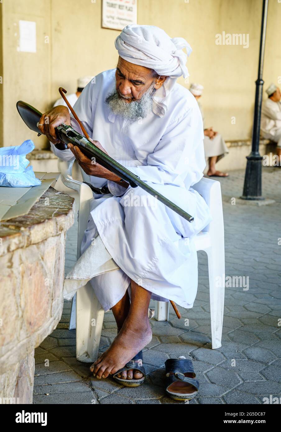 Nizwa, Oman, 2 dicembre 2016: Un anziano sta ispezionando un fucile da caccia al mercato delle armi del venerdì a Nizwa, Omam Foto Stock