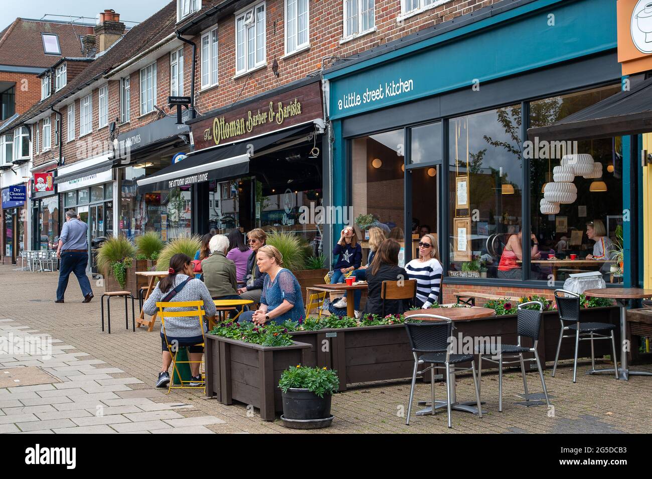 Amersham, Buckinghamshire, Regno Unito. 25 Giugno 2021. I clienti si cuciscono all'esterno di un bar. La gente stamani stava godendo le temperature più calde in Amersham mentre la città torna alla vita dopo l'allentamento di alcune delle restrizioni del Covid-19. Il tasso di casi positivi di Covid-19 per 100,000, tuttavia, è aumentato in Chilterns a 70.9, (68) per la settimana che termina il 21 giugno dal 39.6, (38) dalla settimana prima. Credito: Maureen McLean/Alamy Foto Stock