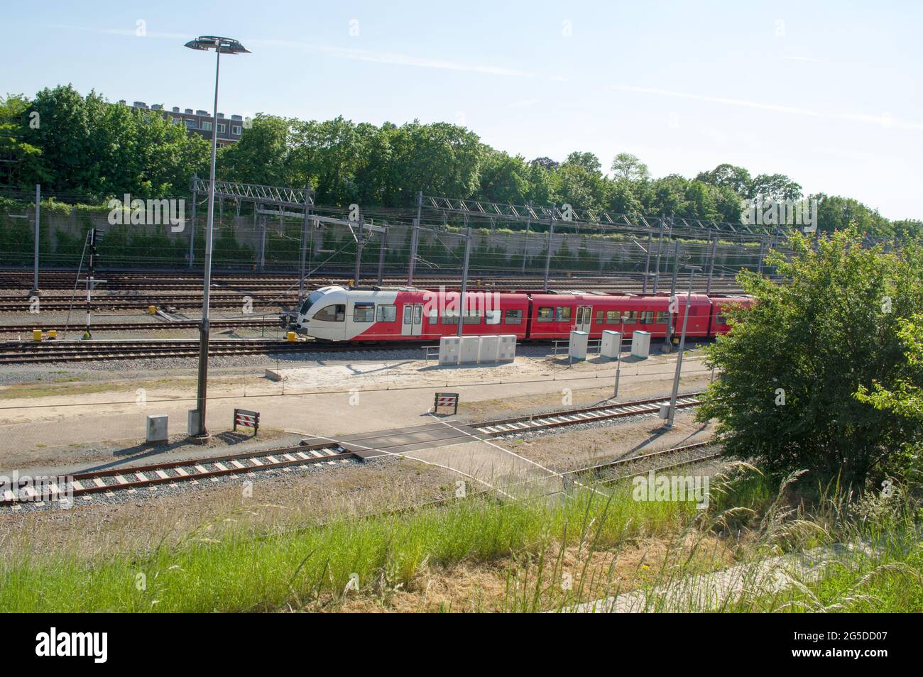Treno rosso e bianco parcheggiato vicino alla stazione Arnhem nei Paesi Bassi Foto Stock
