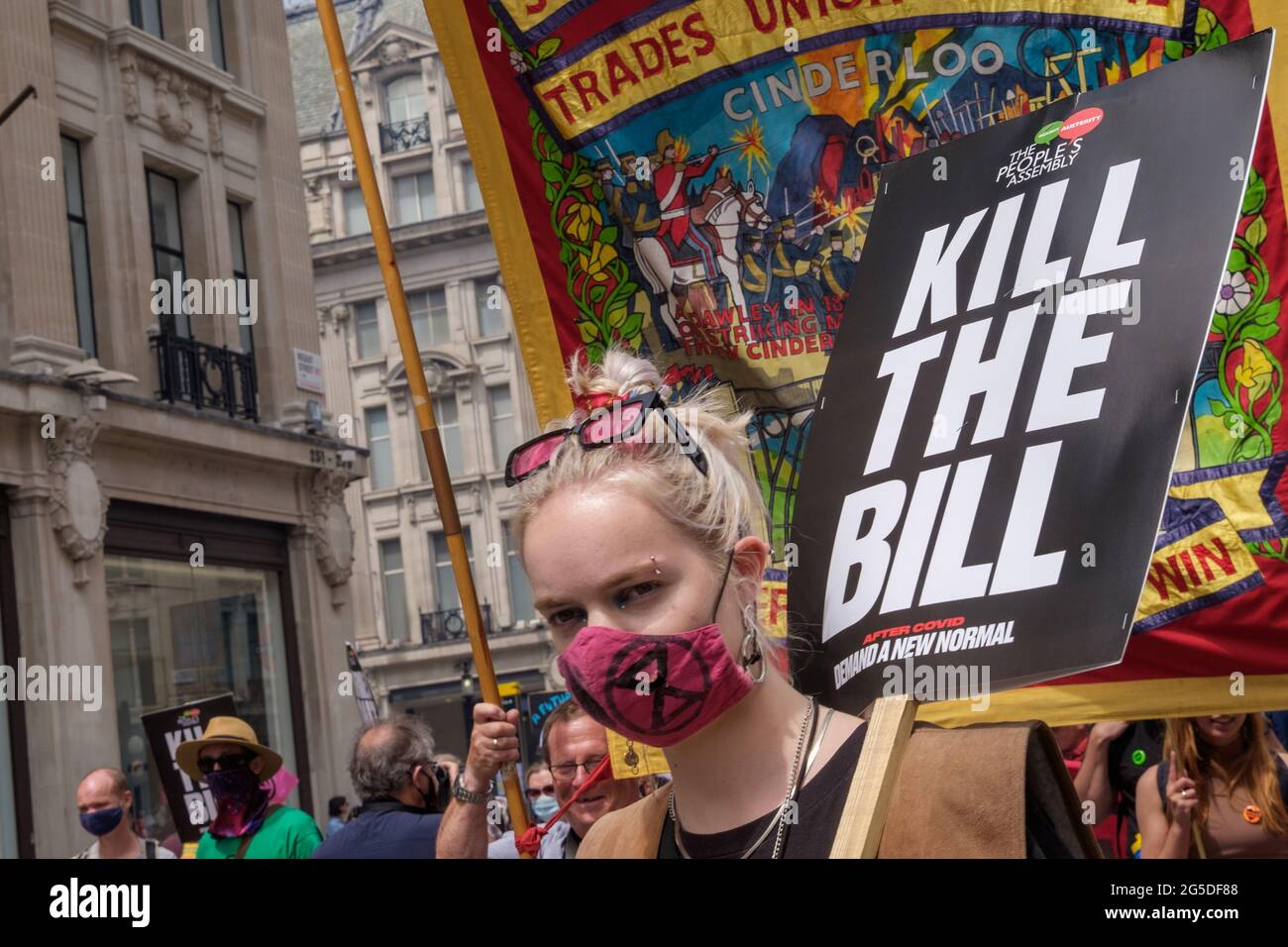 Londra, Regno Unito. 26 giugno 2021. Donna con Kill la targhetta Bill. Oltre cinquemila persone si sono unite all'Assemblea popolare per attraversare Londra contro i fallimenti del governo Tory durante la pandemia, agendo troppo tardi, consegnando contratti a amici e non riuscendo a premiare i lavoratori chiave per i loro sacrifici. Hanno chiesto una "nuova normalità" con la fine della privatizzazione dell'NHS, alloggi dignitosi, un'azione reale sul cambiamento climatico, alloggi dignitosi, la fine di pratiche occupazionali sleali e il saccheggio di politici corrotti. Peter Marshall/Alamy Live News Foto Stock