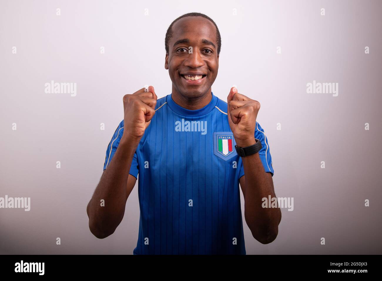tifoso italiano è felice per la vittoria d'italia, tifoso festeggiando, afro ragazzo italiano con la maglia della nazionale di calcio Foto Stock