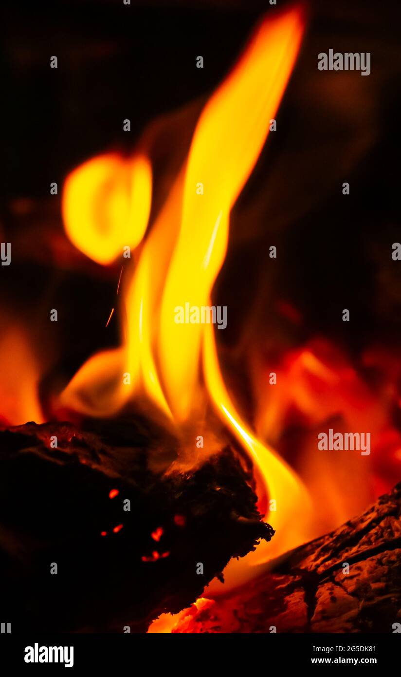 L'energia termica si colma da vicino, rossa e gialla, al punto di alimentazione durante la notte. Fuoco con uno sfondo nero per la carta da parati. Foto Stock