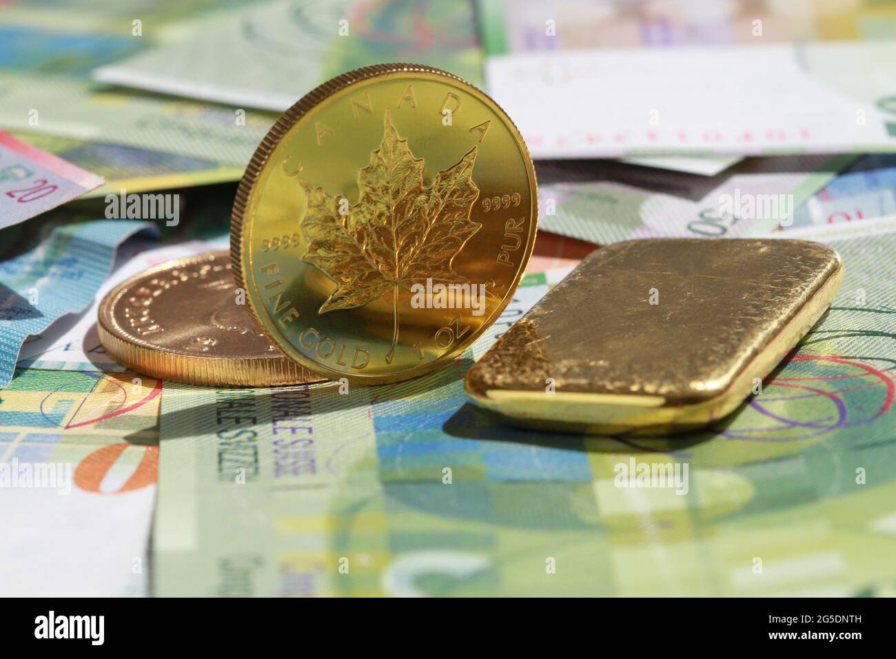 monete d'oro e bar sulle banconote svizzere Foto Stock