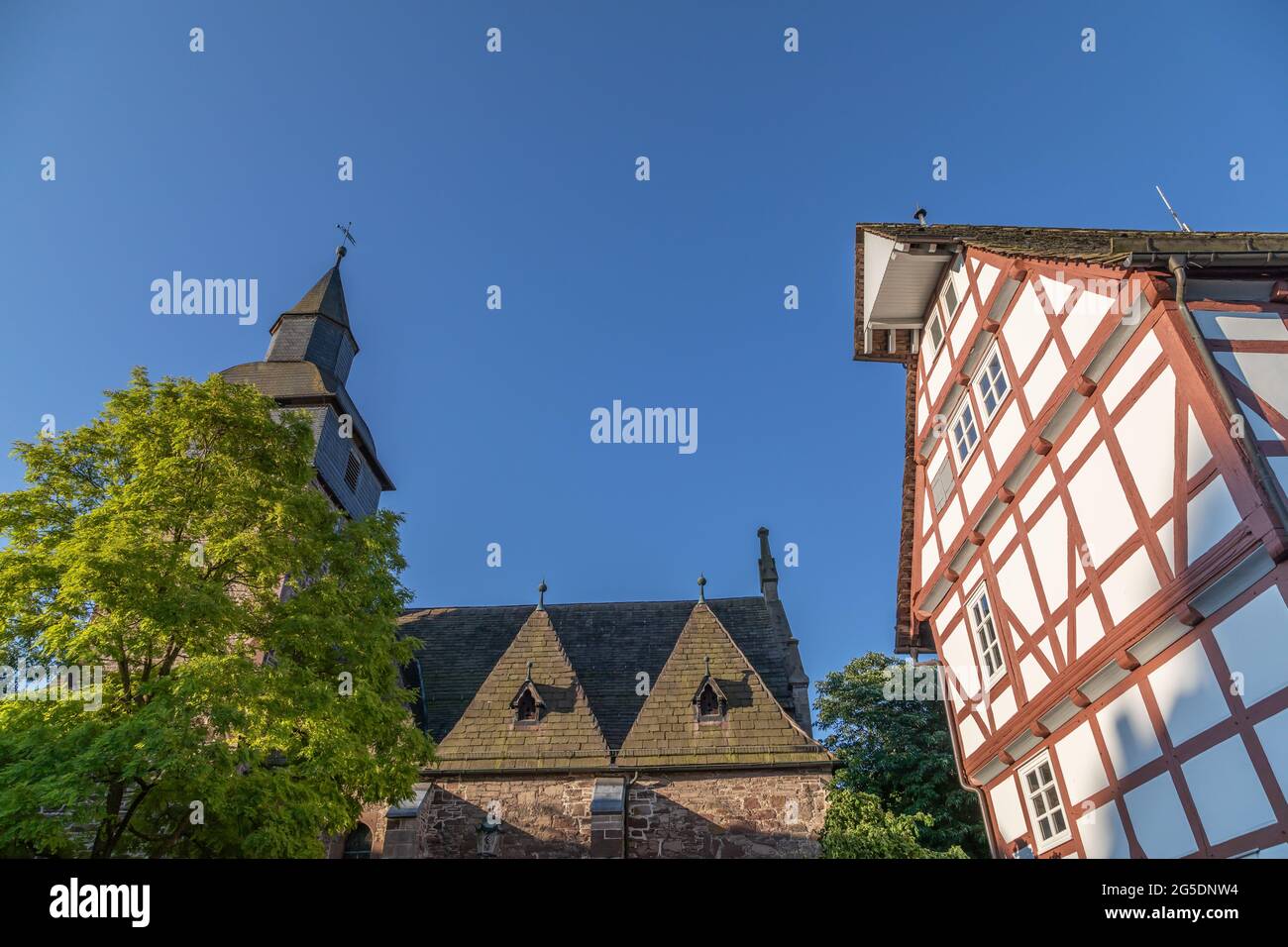 Casa a graticcio e chiesa nella piccola città di Trendelburg Foto Stock