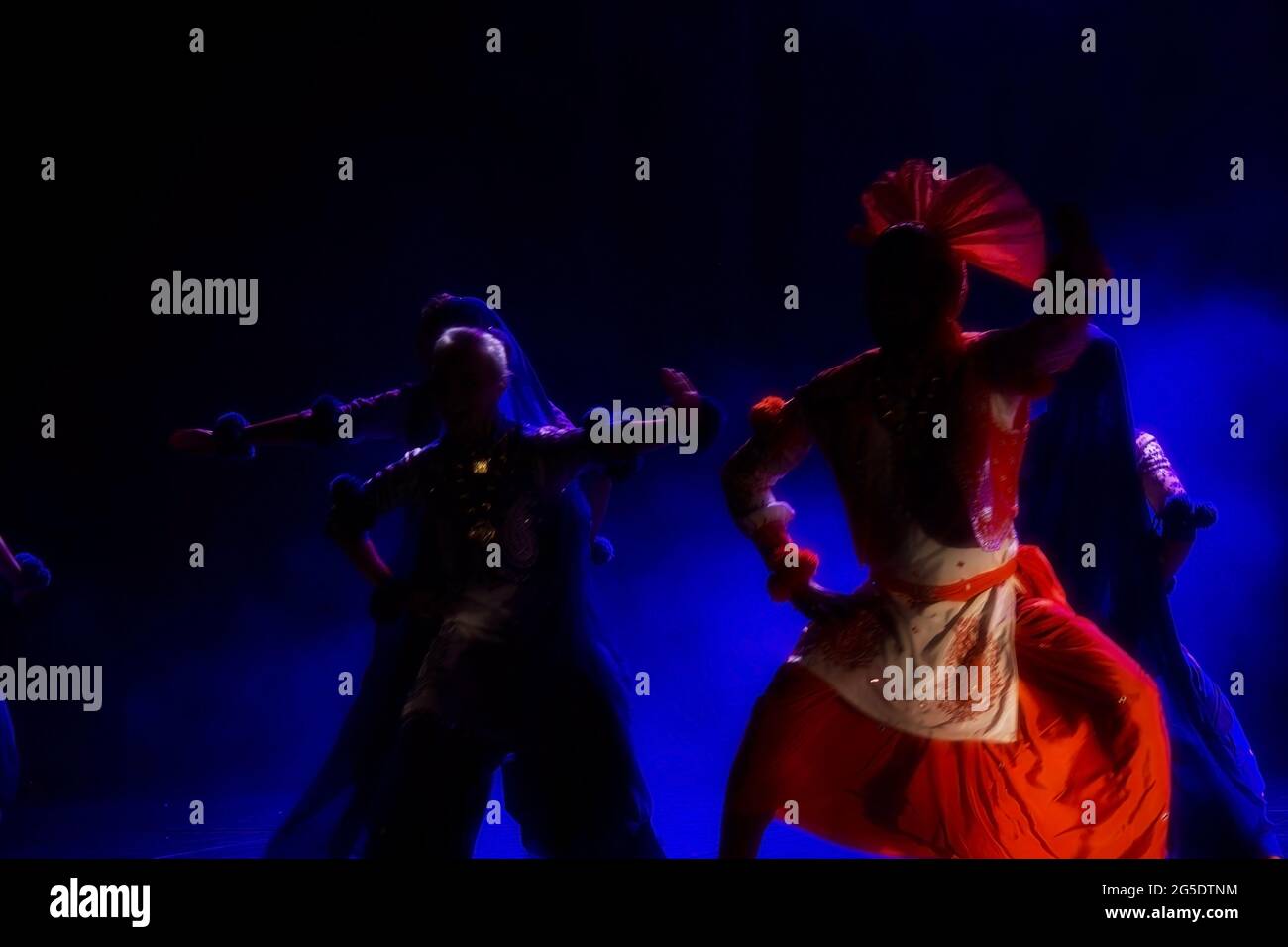 Cracovia, Polonia - 07 aprile 2018: Silhouette di mazzo di persone non identificate che eseguono la famosa danza Punjabi chiamato Bhangra in colorato dre tradizionale Foto Stock