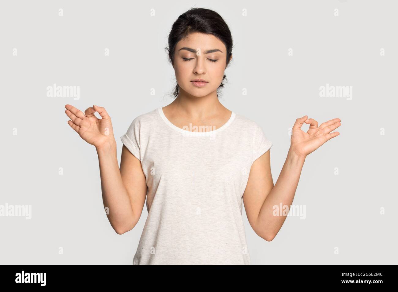 Calma donna indiana pratica yoga alleviando la negatività Foto Stock