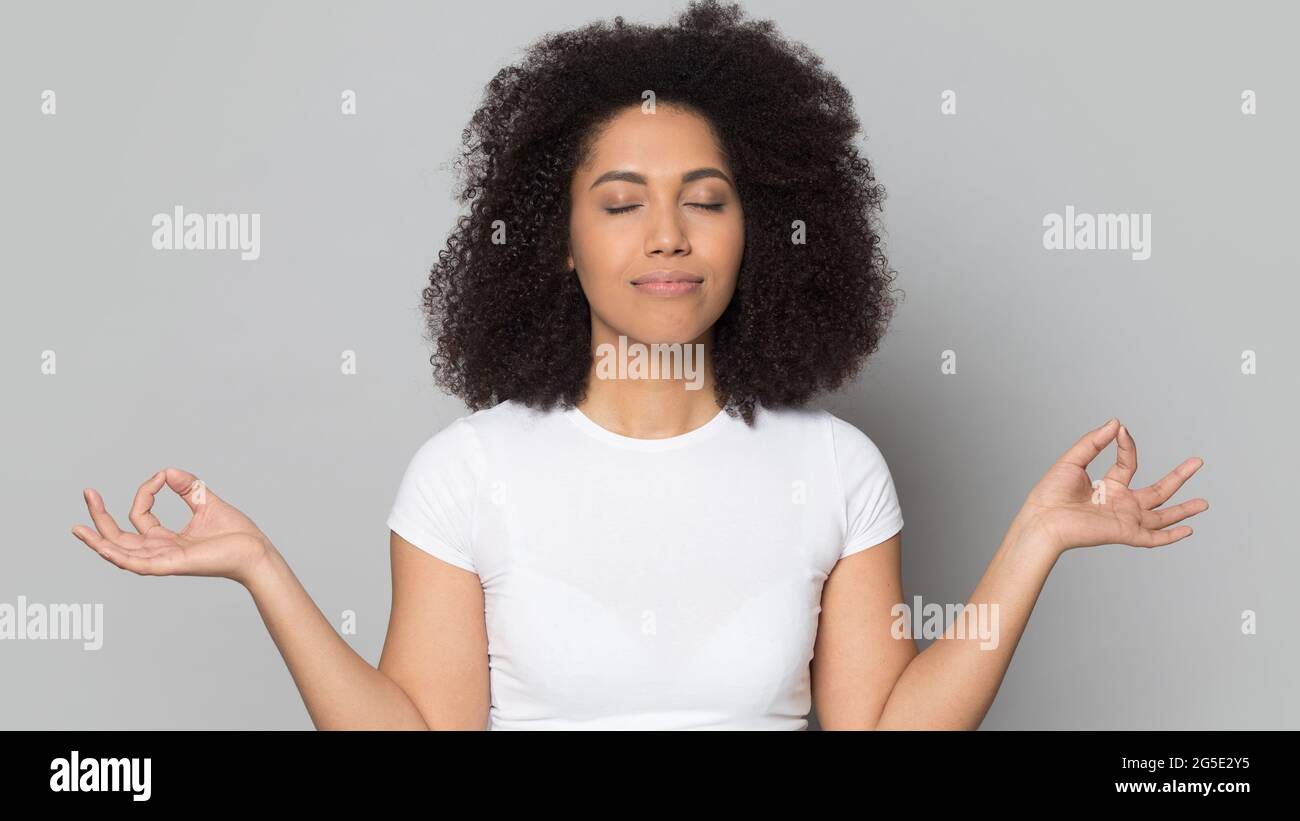 Calma donna afroamericana meditate in studio Foto Stock