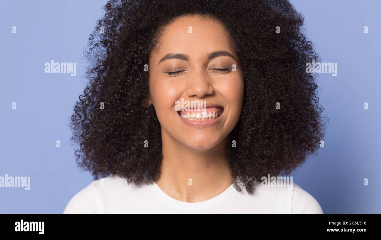 La donna afro-americana eccitata mostra denti sani Foto Stock