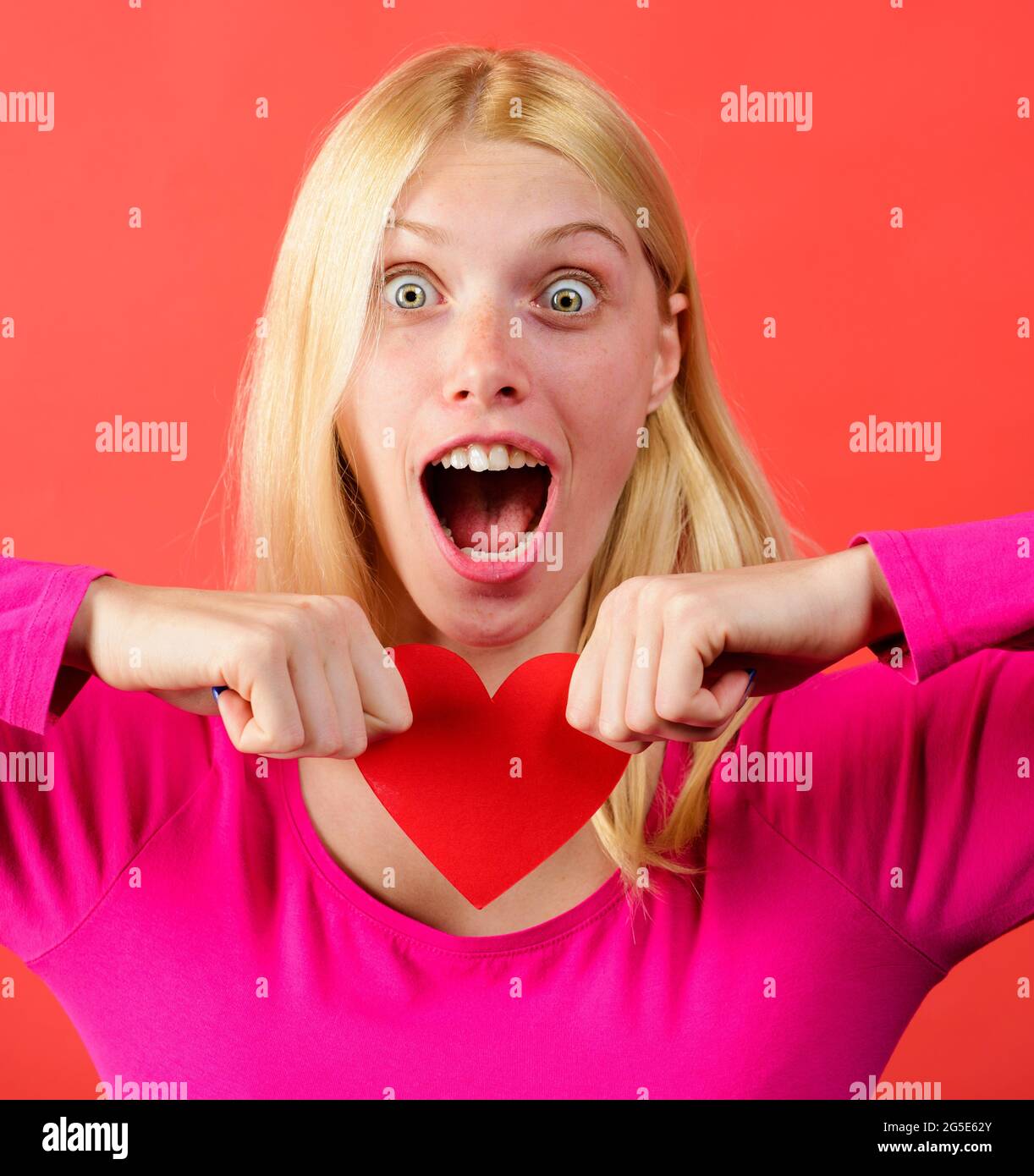 Bella ragazza strappando cuore di carta rosso. Interruzione delle relazioni. Problemi di relazione. Amore non riquintato. Foto Stock