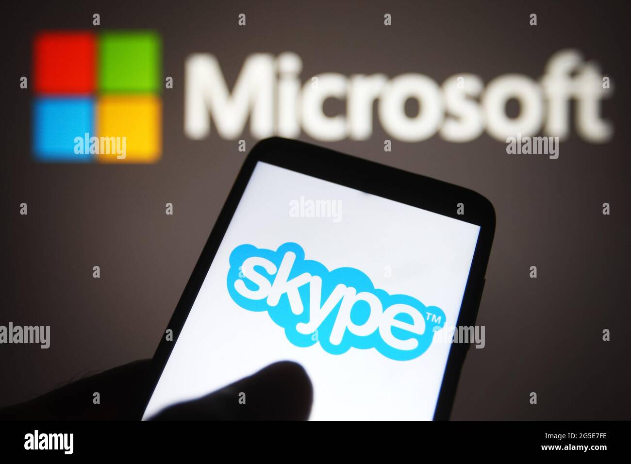 In questa illustrazione fotografica viene visualizzato un logo Skype sullo schermo di uno smartphone con un logo Microsoft sullo sfondo. Foto Stock