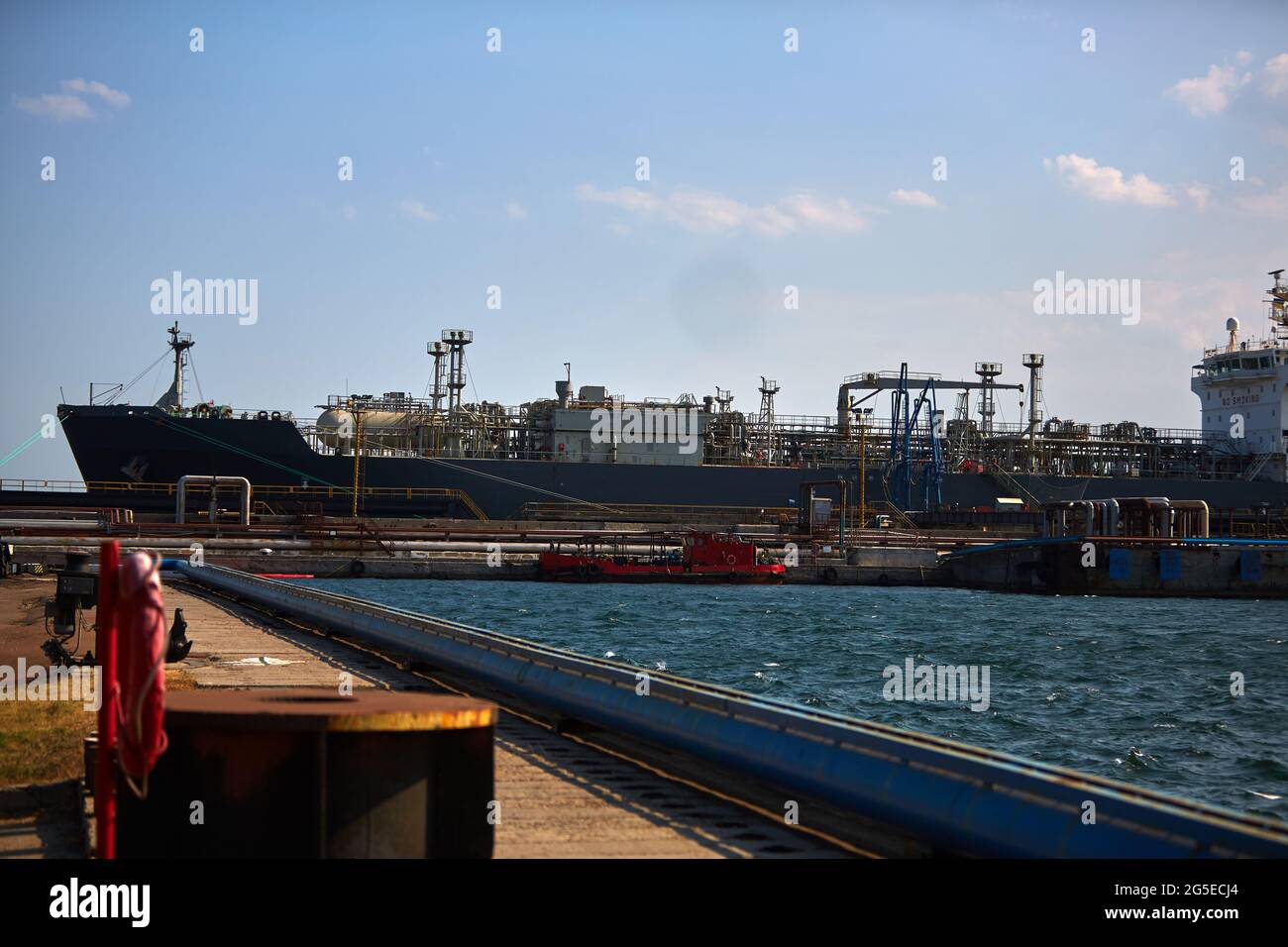 la nave mercantile è un vettore di gas al terminale portuale. La petroliera al terminale del porto industriale carica con gas, scarica il gas. Foto Stock