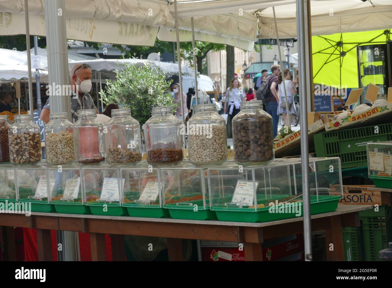 Viktualienmarkt Monaco, mercato giornaliero. Caraffe con noci, mandorle, frutta secca su una stalla con cibo fresco. Foto Stock