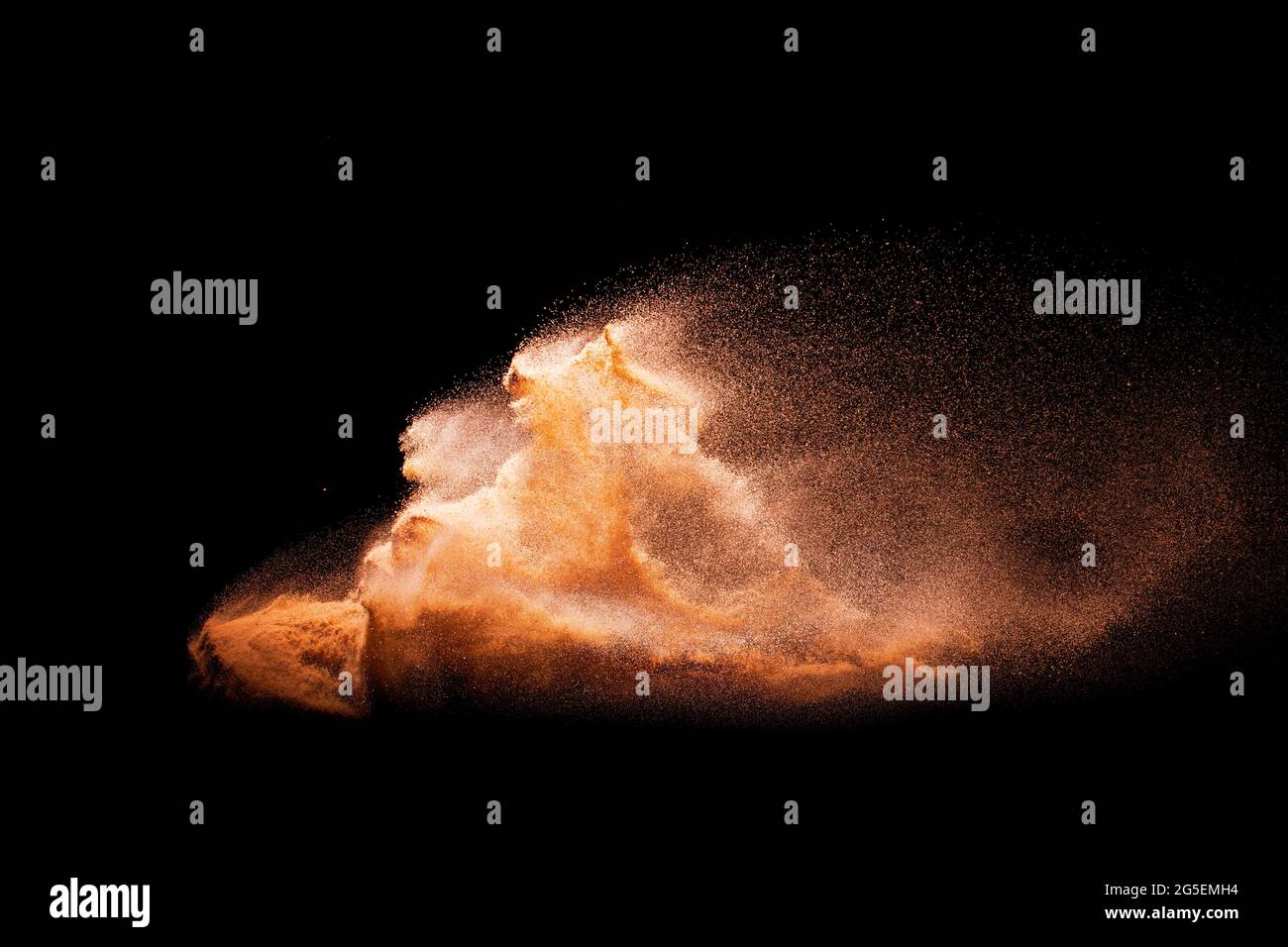La sabbia di colore marrone si spruzzi su sfondo nero. Foto Stock