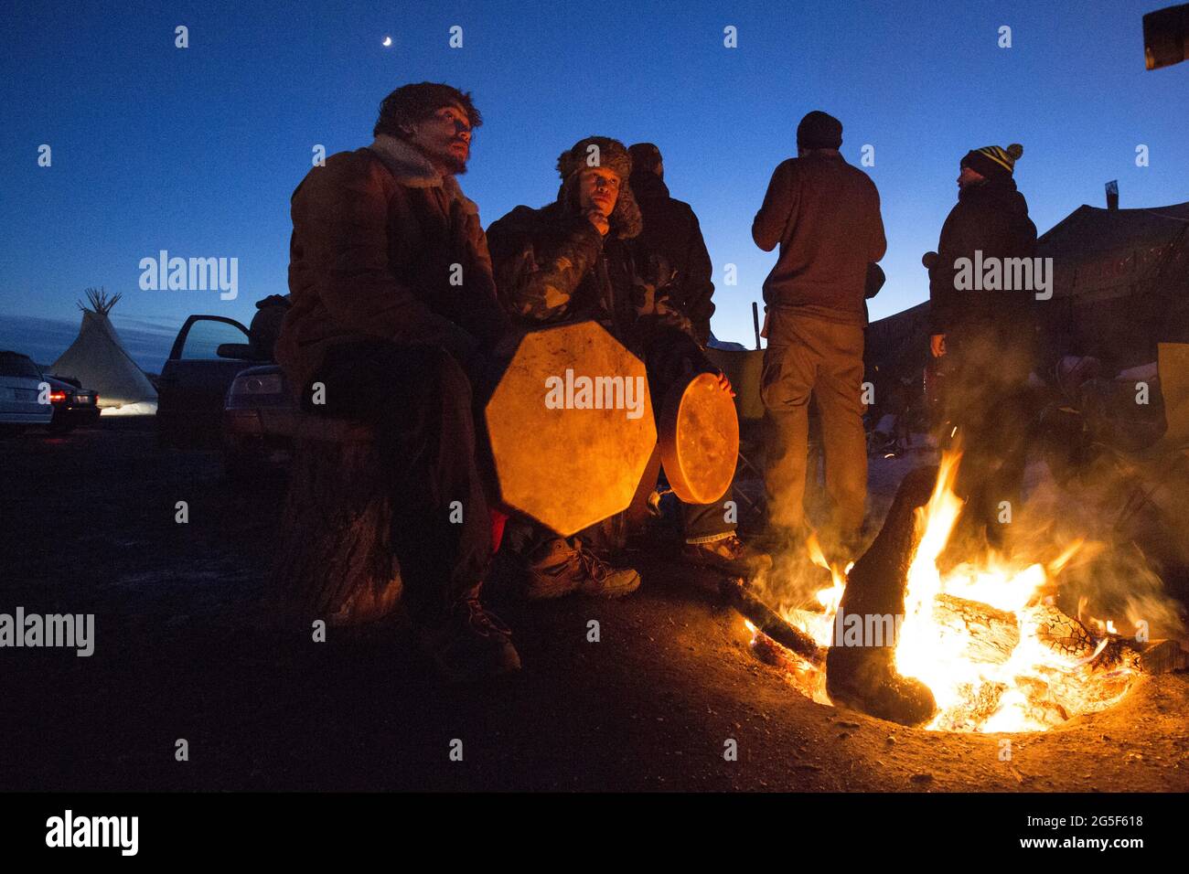 Steven Tababoo (t.h) og Teewahnee Sahme feirer seieren over DAPL med sang og trommer i oceti Sakowin-leiren. Etter måneder med protester klarte Sioux-indianerne ved Standing Rock og deres støttespillere å stoppe US Army Corps of Engineers fra å bygge den omstridte DAPL - Dakota Access Pipeline - Under relven som går rett gjennom Dakota-indianernes reservat. Aksjonene fikk også gamle motsetninger mellom insanerne og norskamerikanerne til overflaten. Foto Stock