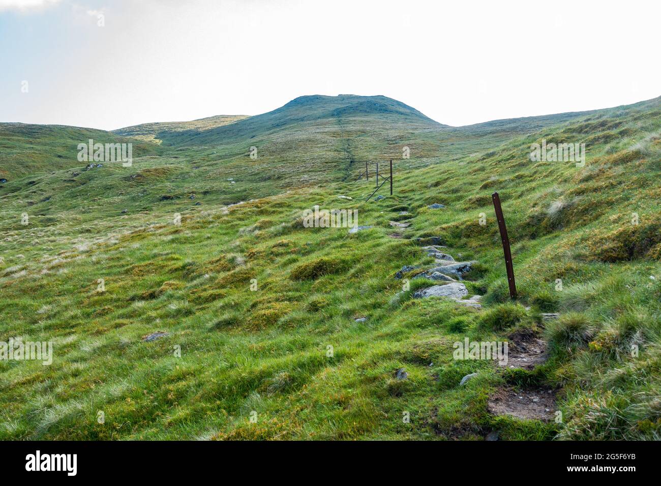 I vecchi pali di recinzione mostrano il percorso fino alla montagna munro di Meall Corranaich, parte della gamma ben Lawers in Scozia Foto Stock