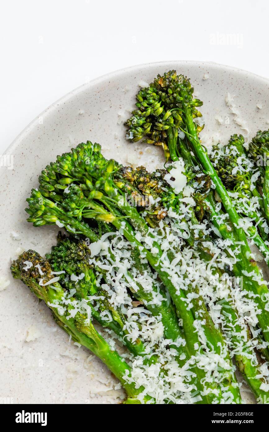 Broccolini freschi cotti con formaggio grattugiato e sul piatto Foto Stock