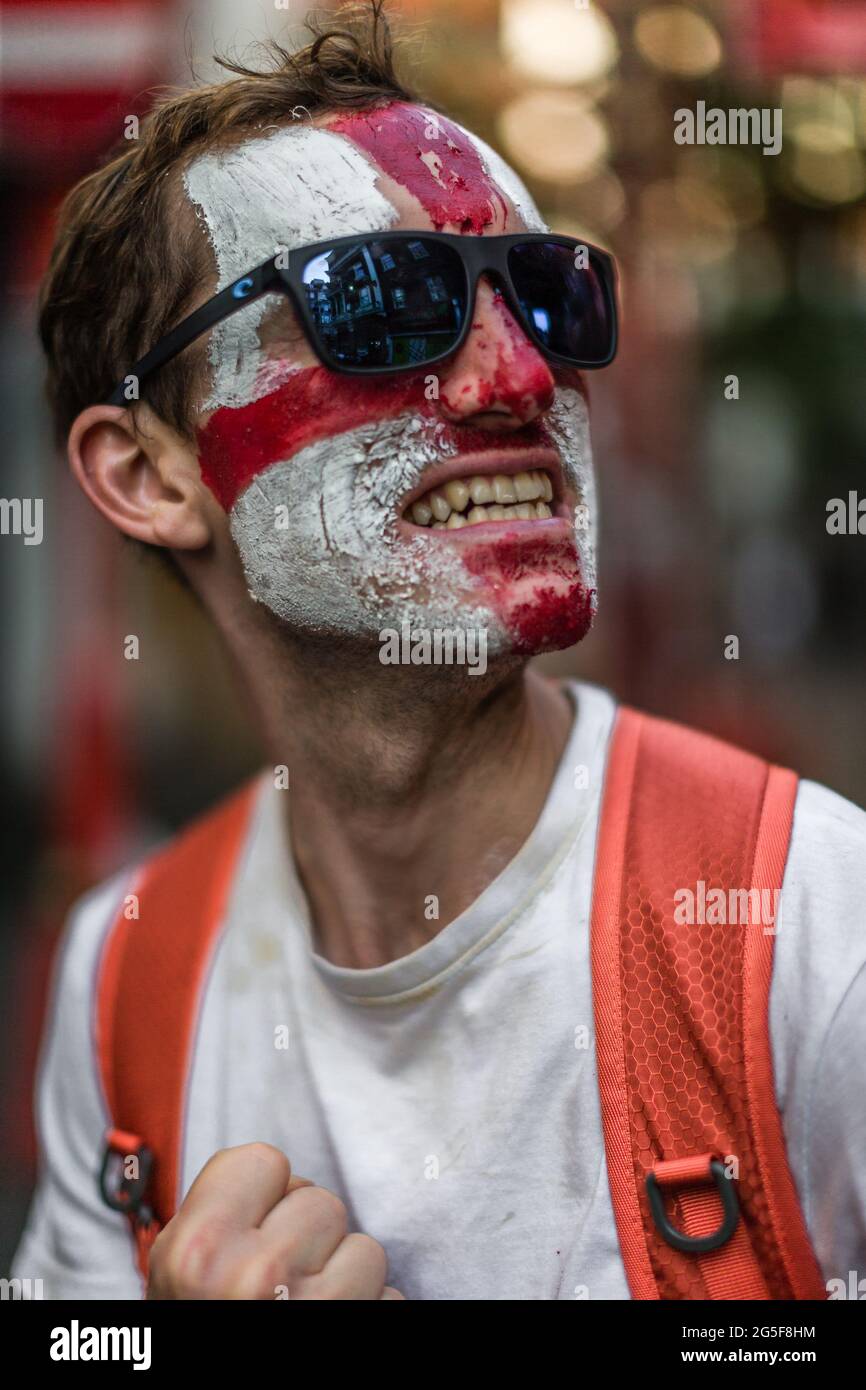 Un appassionato di calcio inglese sorride mentre attende con impazienza la partita semifinale contro la Danimarca nel ritardato EURO 2020 Foto Stock