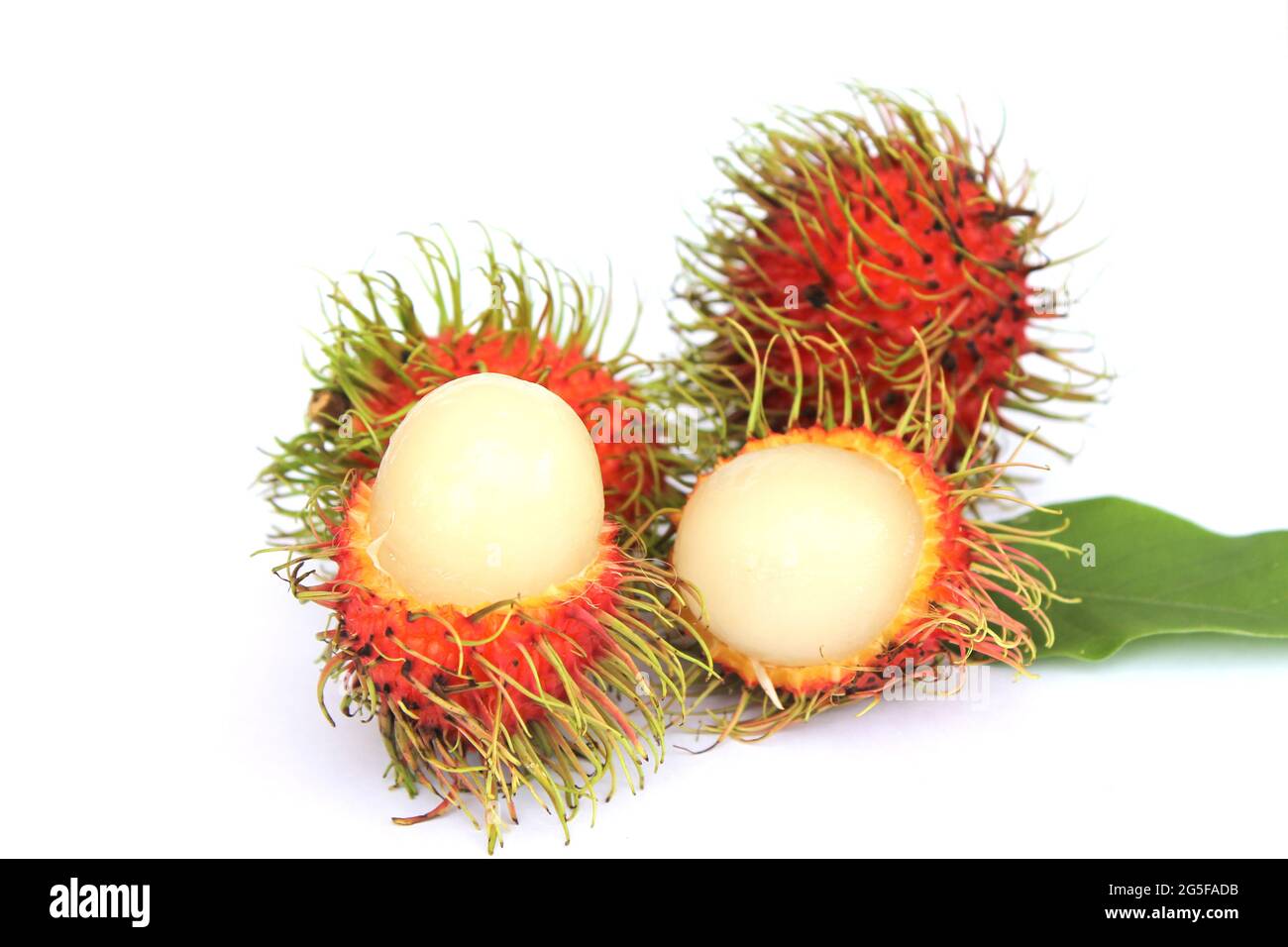 Rambutan dolce, frutta popolare in Thailandia isolato su sfondo bianco. Sbucciare la pelle per rivelare i semi all'interno. Con le foglie Foto Stock