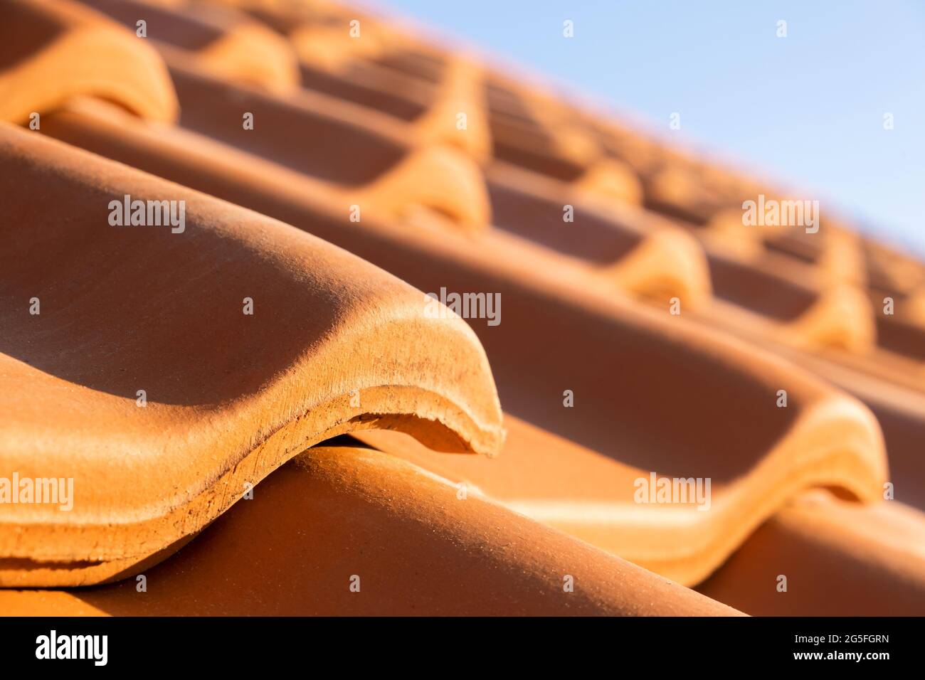 File sovrapposte di tegole in ceramica gialle che coprono il tetto dell'edificio residenziale. Foto Stock