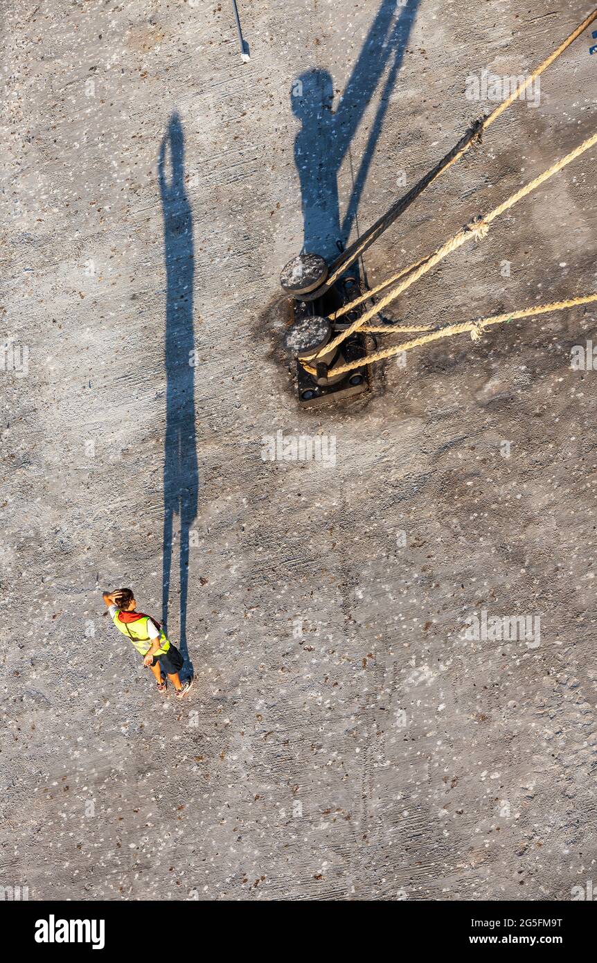 L'uomo graffiando la testa fingendo di chiedersi come gettarsi via. Porto di Ajaccio, Corsica, Francia Foto Stock