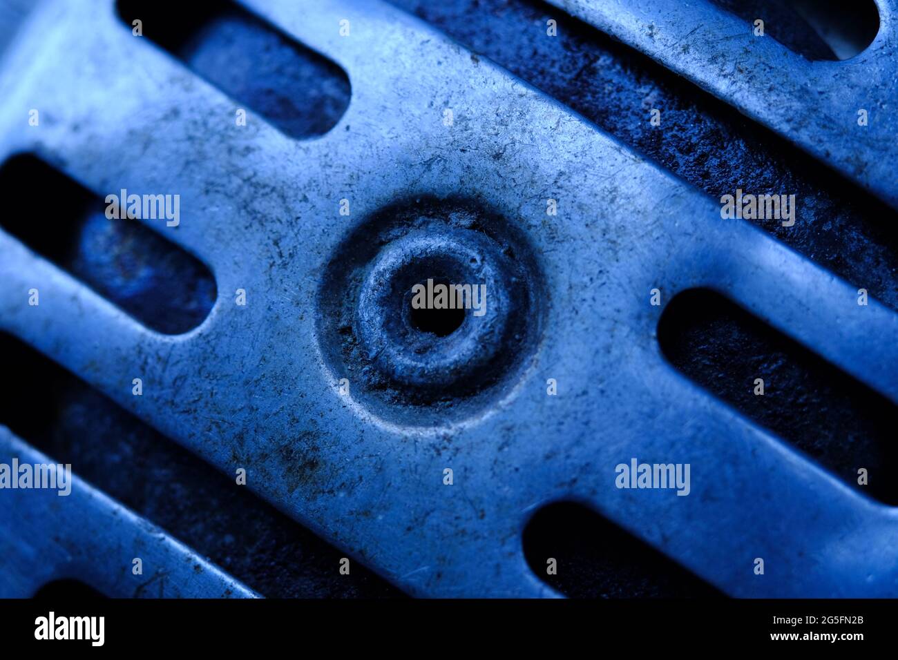 Macro fotografia automobilistica. Chiudere il foro della vite su un acciaio sterzante. Tono freddo Foto Stock