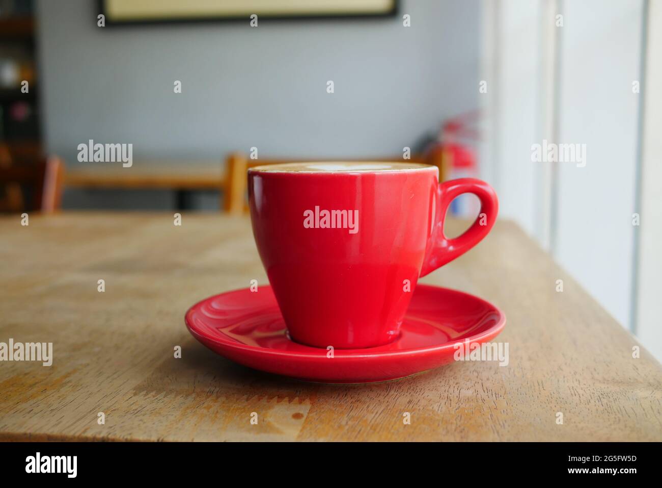 primo piano della tazza di caffè di colore rosso sul tavolo al caffè Foto Stock