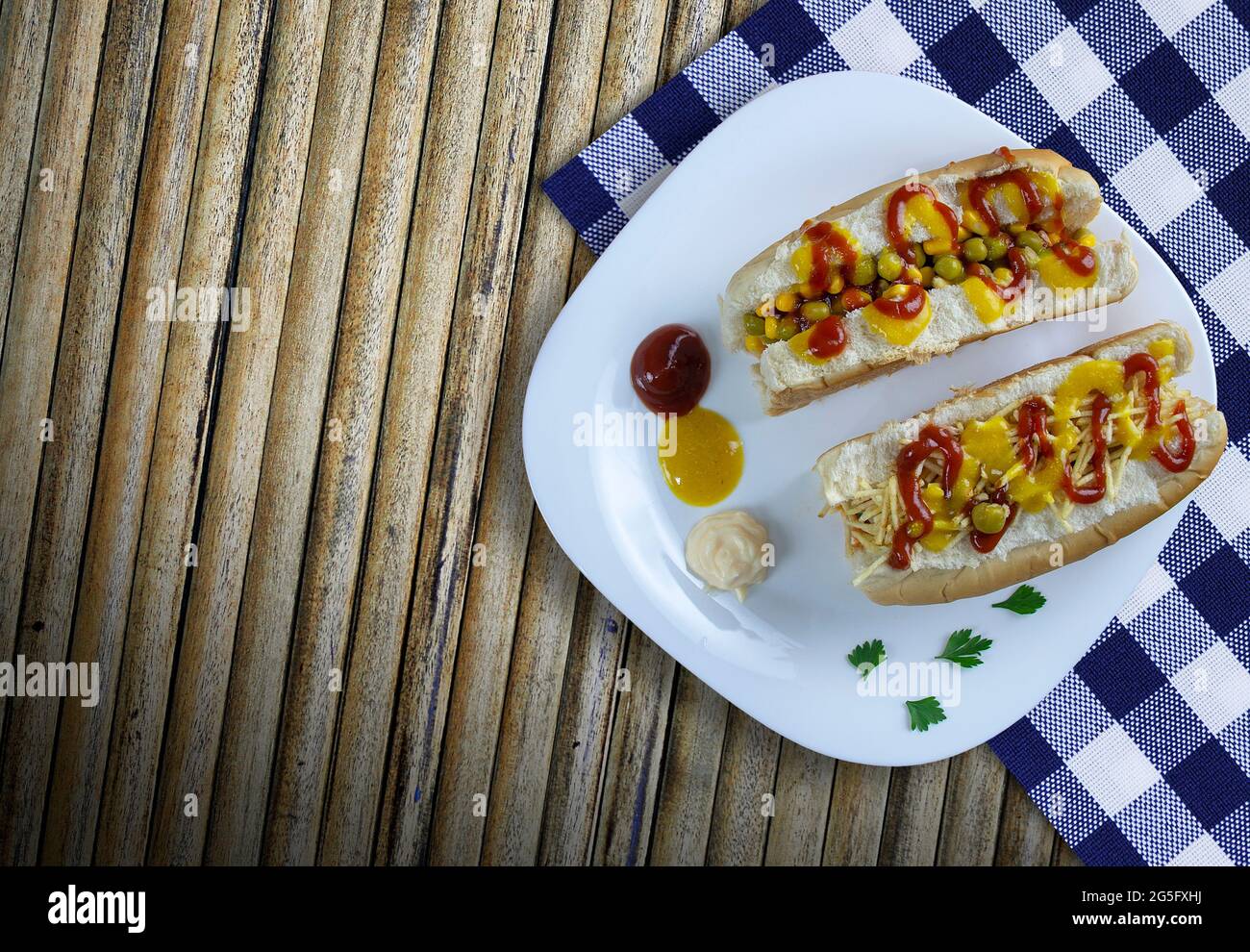 Hot dog con verdure, senape gialla, ketchup, su fondo di legno. - immagine ad alta risoluzione Foto Stock